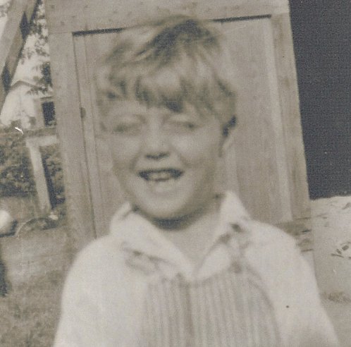 Young James in front of barn